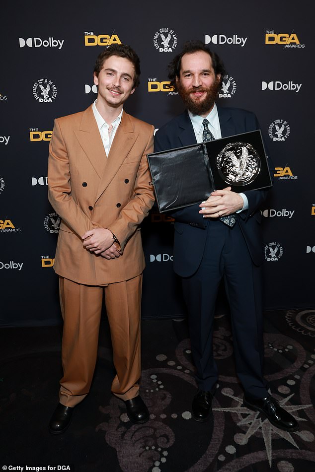 ارتدى تيموثي شخصية أنيقة ببدلة برتقالية مزدوجة الصدر ونسقها مع قميص أبيض بياقة مفتوحة؛ في الصورة مع جوش صفدي