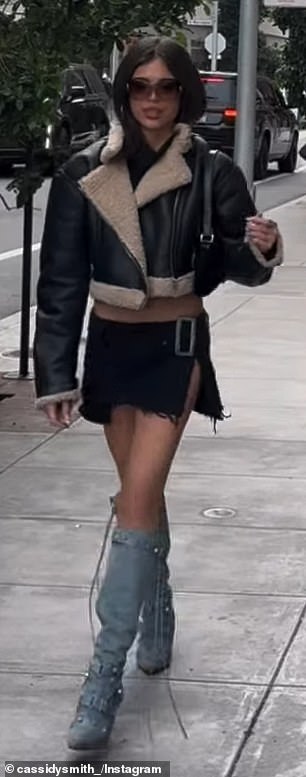 ظهرت جرين على بطنها وفخذيها المشدودين في تنورة قصيرة مقسمة وسترة قصيرة من الشيرلنج وحذاء أزرق يصل إلى الركبة