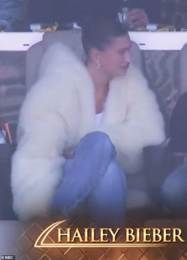 كانت عارضة أزياء Vogue ترتدي سترة بيضاء قصيرة قصيرة فوق قمة بيضاء مع بنطال جينز أزرق باهت من Levi's وأحذية مفتوحة باللون البيج ذات مقدمة مربعة