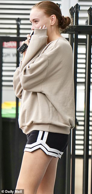 ...باستخدام كم سترتها لتغطية يدها