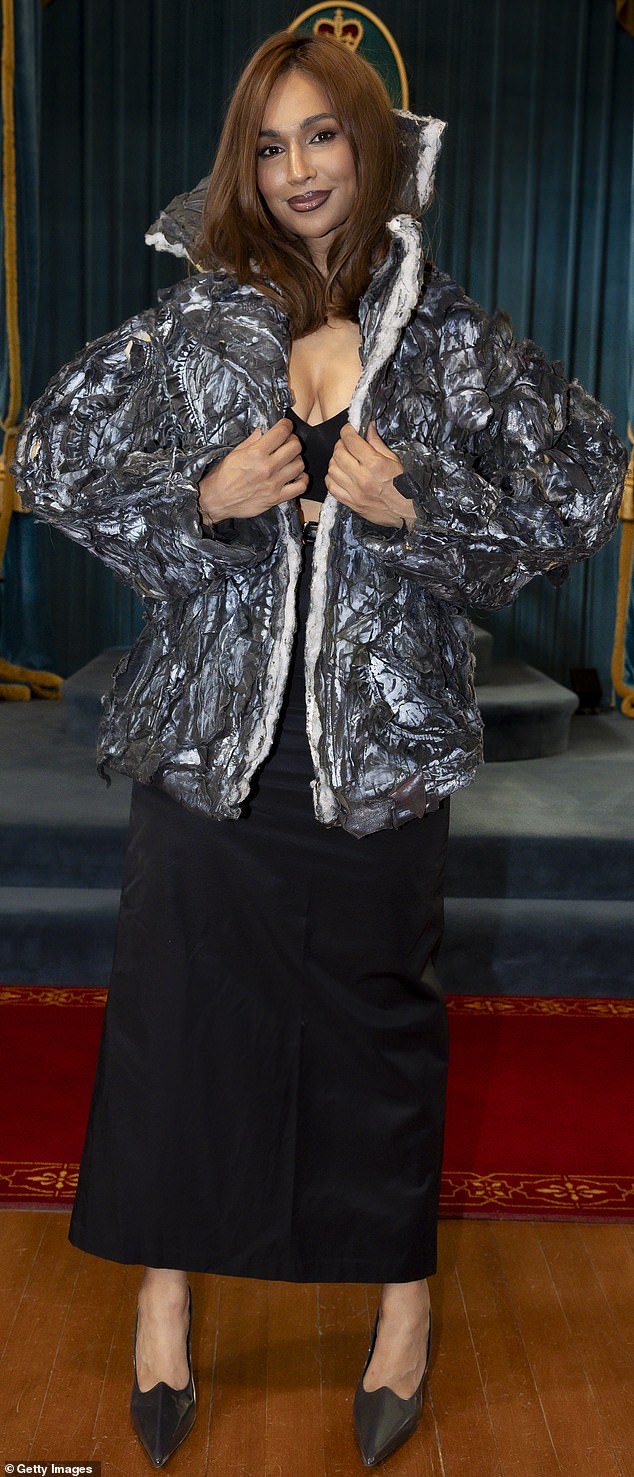 وارتدت نجمة الجيران شارون قميصها الذي يتميز بزخرفة صوفية بيضاء مع الياقة لأعلى. كانت ترتدي أيضًا قميصًا أسودًا مكشوفًا منخفض القطع يتباهى بصدرها وتلميحًا من الحجاب الحاجز