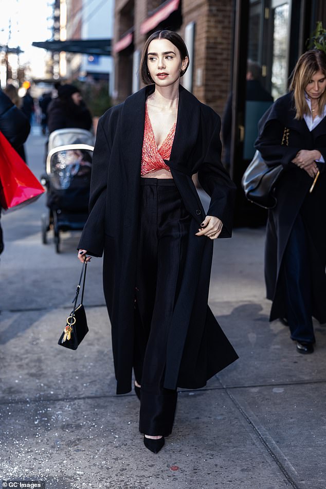 أذهلت الممثلة إميلي إن باريس عندما ارتدت معطفًا طويلًا أسود اللون فوق الجزء العلوي من الترتر