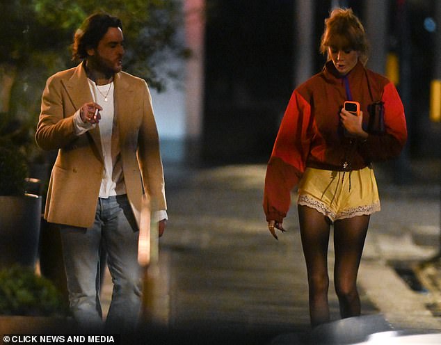 وفي الوقت نفسه، كان بيت، 37 عامًا، يرتدي سترة بيج فوق قميص أبيض وجينز وهو يدخن سيجارة أثناء الدردشة مع الجميلة الشقراء على الرصيف.