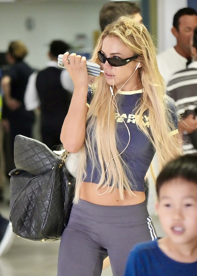 فشلت الشقراء في رسم ابتسامة وهي تمسك بهاتفها وتسحب حقيبتها خلفها